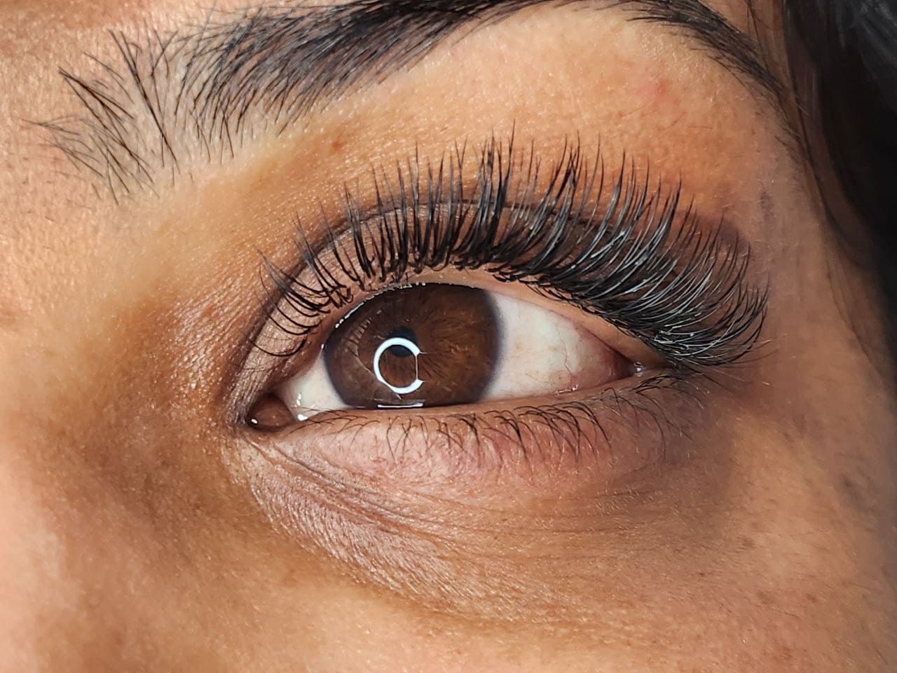 Happy client smiling confidently after receiving hybrid eyelash extensions from Diamond Eyelash Extensions in Melbourne, showcasing the satisfaction and boost in self-esteem.