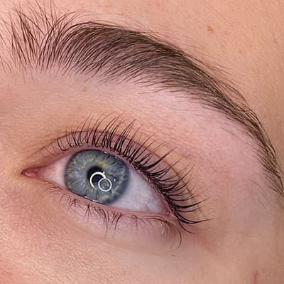 Lifted and tinted lashes by Diamond Eyelash Extensions in Melbourne on dark eyes, showcasing the enhancement of natural beauty and definition.